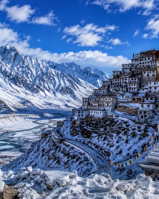 Key Monastery under snow, beside the sign at the entrance to the Spiti valley