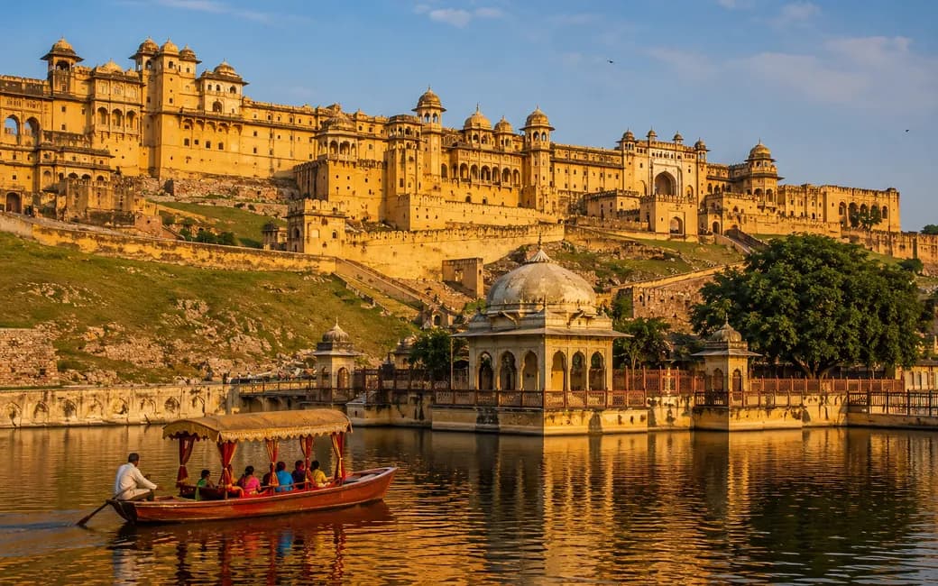 A hilltop Rajasthan fort palace above its lake, with a boat on the water