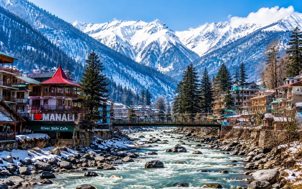 The town of Manali beside its rocky river, under snow-covered peaks